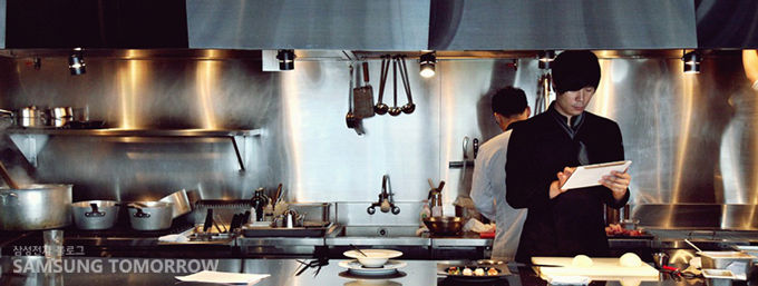 갤럭시탭을 들고 있는 최현석 셰프