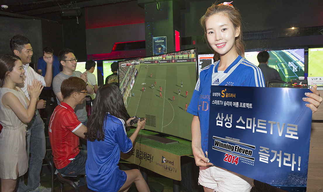 삼성 스마트TV로 즐기는 축구 게임 ‘위닝일레븐’ 내용의 간판을 들고 있는 여자의 모습