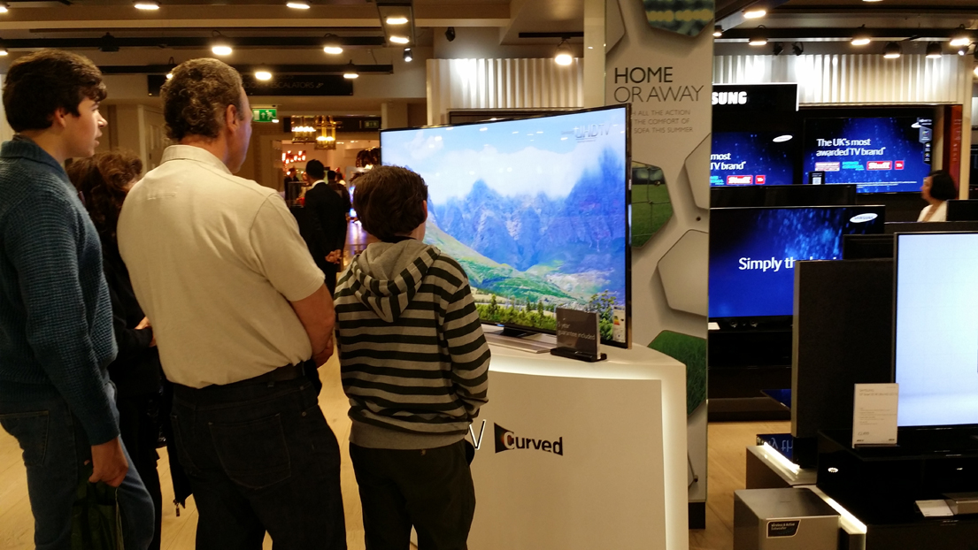 런던 헤롯백화점 삼성전자 매장에 전시돼 있는 커브드 UHD TV를 영국인 가족이 시청하고 있다.