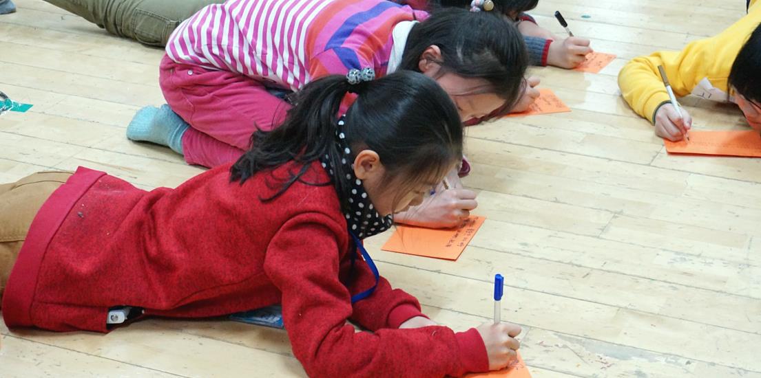 삼성전자 어린이 기자단 겨울캠프에서 어린이 기자단이 가고 싶은 여행지에 대한 홍보지를 직접 작성하고 있는 모습