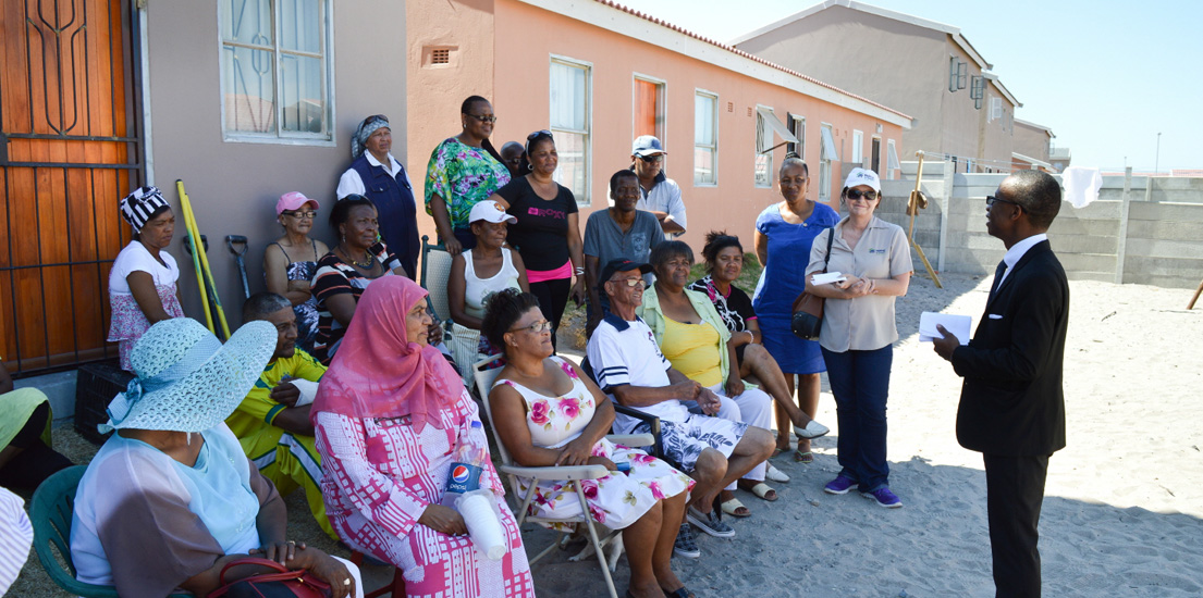 남아공 주민들이 완공된 주택 앞에 모여 이야기를 하고 있습니다