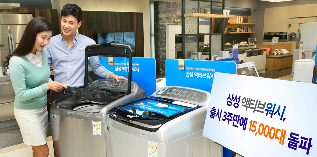 남녀 모델이 삼성 액티브워시 세탁기를 보고 있습니다. 오른쪽엔 삼성 액티브워시 출시3주만에 15,000대 돌파라는 푯말이 옆에 있습니다.