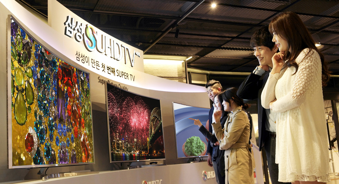삼성 SUHD TV 백화점 로드쇼 현장 사진입니다. 관람객들이 SUHD TV를 체험하고 있습니다.
