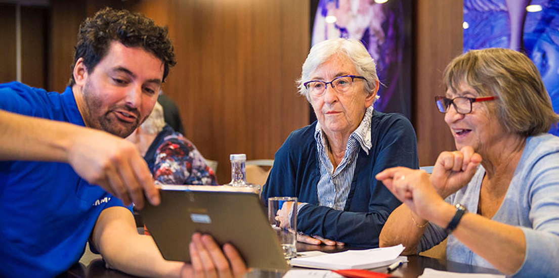 삼성전자 직원이 실버세대에 태블릿을 보여주며 온라인 서비스 이용방법을 설명합니다.