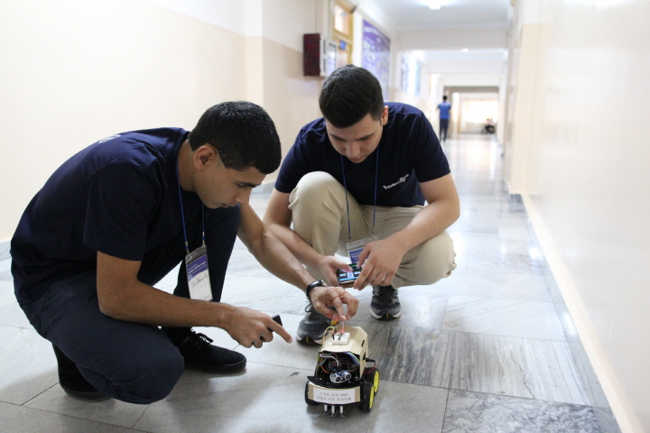 올해 열여섯 살이 된 무러드(Muzod)과 쇼흐루흐(Shokhrukh)이 스마트폰으로 기계를 조종하고있다.