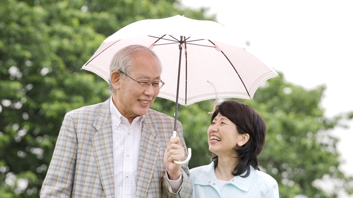 자외선 차단을 위해 양산을 쓴 부부
