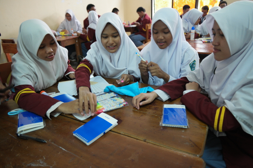 히잡을 두른 여성들이 스마트폰을 보고있다.