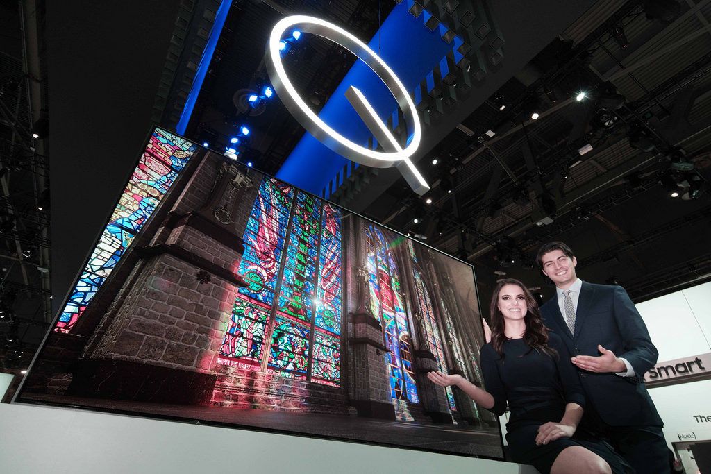 CES 2017 전시회에서 남녀 모델이 삼성 QLED TV를 소개하고 있는 이미지