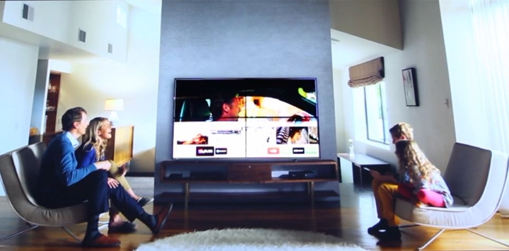 QLED TV를 시청하는 네 가족(아버지,어머니,아들,딸)