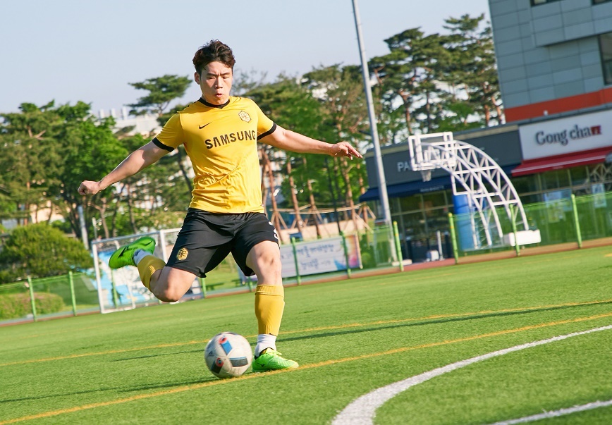 잔디구장에서 공차기를 하는 남자