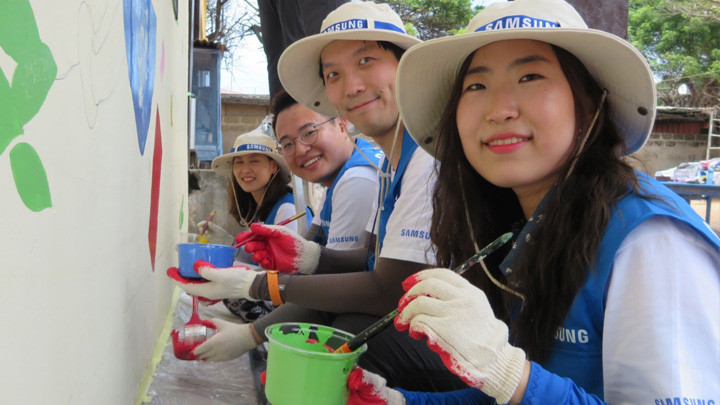 벽화를 그리고 있는 삼성전자 임직원들의 모습