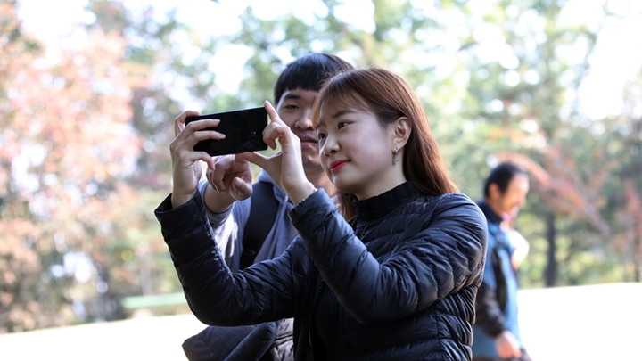 갤럭시 노트8 활용하며 가을 풍경을 담고 있는 2명