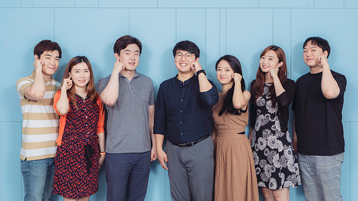 ▲이놈들연구소 팀원들이 손끝을 귀에 댄 ‘시그널’ 포즈를 취하고 있다