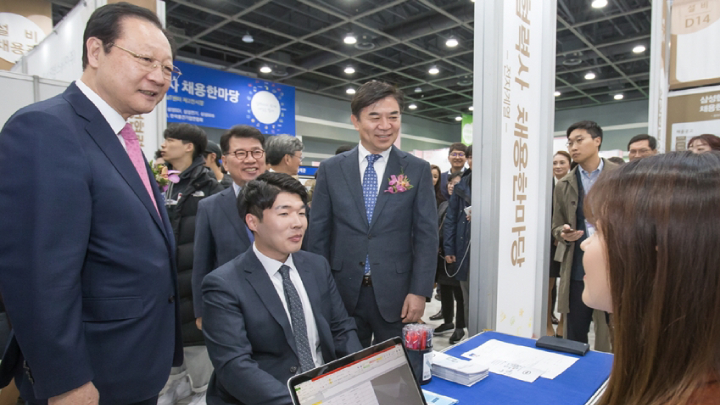 11월 12일 서울 aT센터에서 열린 ‘2018 삼성 협력사 채용 한마당’을 찾은 구직자가 삼성전자 반도체 협력사 ‘피에스케이’ 부스에서 채용 면접을 보고 있다. 이 자리를 찾은 동반성장위원회 권기홍 위원장(왼쪽)과 삼성전자 김현석 대표이사 사장(오른쪽)이 면접을 보는 구직자(가운데)를 응원하고 있다.