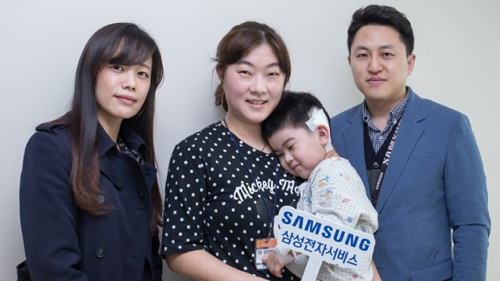 삼성전자서비스의 후원으로 인공으로 인공달팽이관 수술을 받은 아동과 어머니(가운데)가 사랑의달팽이 재단 관계자(좌)와 삼성전자서비스 한마음협의회 오지상 대표위원(우)과 기념 사진 촬영을 하고 있다.