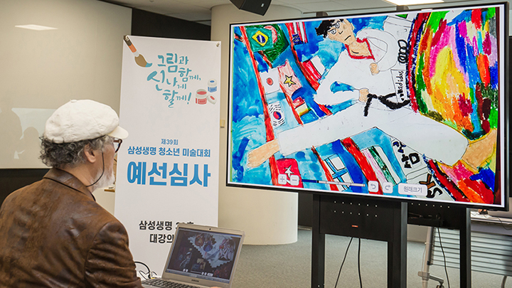 한국미술협회 김종수 부이사장이 23일 서울 서초동에 위치한 삼성생명 대강의장에서 삼성 QLED 8K TV를 활용해 삼성생명이 주최하는 ‘제39회 청소년 미술대회’ 예선 작품을 심사하고 있다.