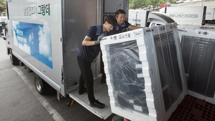 삼성전자 제품 배송·설치 담당자들이 17일 경기도 고양시 일산서구에 위치한 삼성전자 서서울물류센터에서 삼성 건조기 그랑데를 배송하기 위해 차량에 싣고 있다. 삼성 건조기 그랑데는 높은 습도로 인해 빨래가 잘 마르지 않는 장마철 필수 가전으로 인기를 얻고 있다.