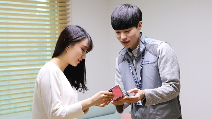 삼성전자서비스 수리 엔지니어가 '휴대폰 방문 서비스'를 신청한 고객의 집을 방문해 점검을 마친 갤럭시 Z 플립을 건네주고 있는 모습