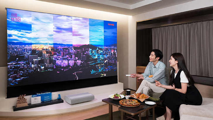 삼성전자 모델이 서울 광장동 워커힐 호텔앤리조트 내 '시네마 스위트 with 삼성 더 프리미어' 객실에서 4K 고화질로 최대 130형의 초대형 화면을 감상할 수 있는 프리미엄 빔 프로젝터 '더 프리미어'와 '더 프리미어' 전용 롤러블 스크린을 체험하고 있는 모습.