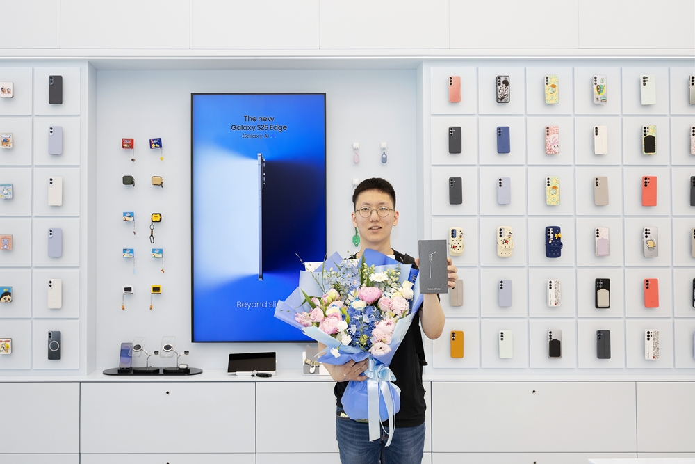 1호 고객 전준하 씨가 갤럭시 S25 엣지를 들고 포즈를 취하고 있다.