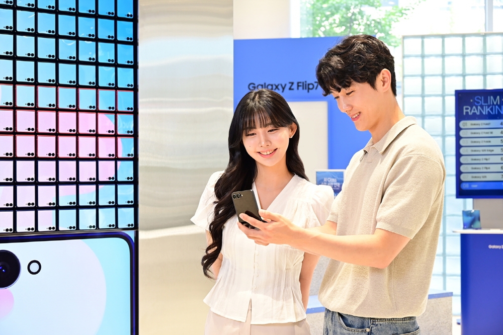 삼성스토어 홍대 '갤럭시 스튜디오'에서 '갤럭시 Z 플립7'의 넓어진 커버 디스플레이를 형상화한 아트 월 앞에서 '갤럭시 Z 플립7'을 사용해보는 모습