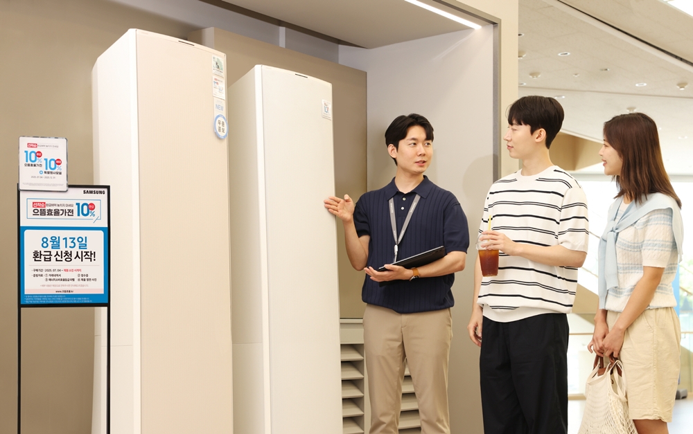 삼성전자 모델이 에너지 소비효율 1등급의 '세탁건조기'와 '에어컨' 제품의 설명을 듣고 있다.