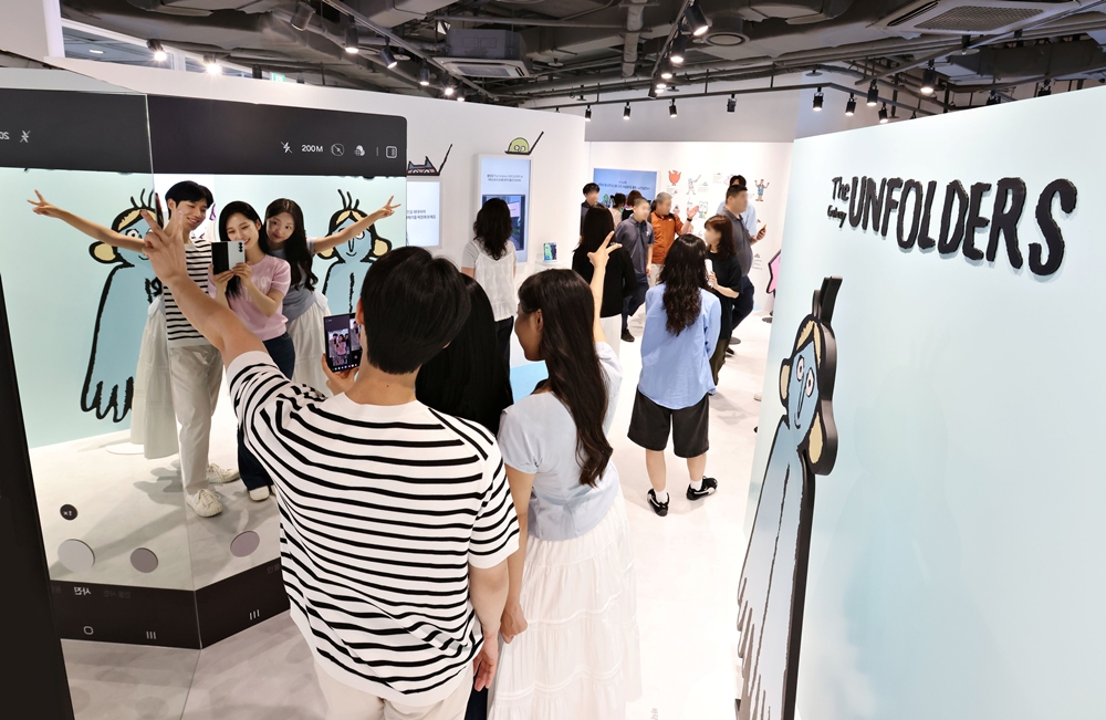 서울 코엑스 ‘The Galaxy UNFOLDERS’ 체험존 방문객들이 ‘갤럭시 Z 폴드7'으로 아티스트 '장 줄리앙(Jean Jullien)'의 캐릭터와 함께 인증샷을 촬영하는 모습