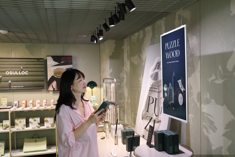 ▲아모레성수 굿즈존에서 삼성 컬러 이페이퍼에 표시된 내용을 살펴보는 방문객