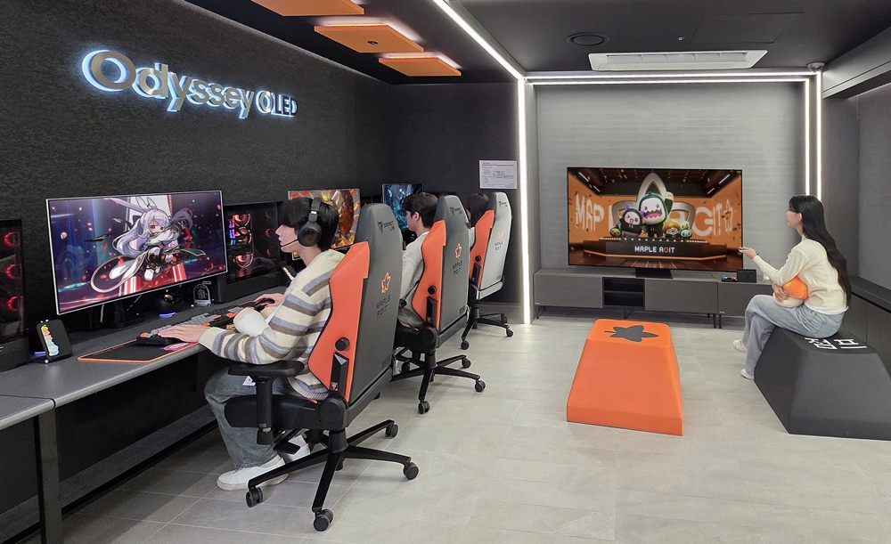 삼성전자 모델이 '메이플 아지트'의 '프리미엄 룸'에서 오디세이 G8으로 게임을 플레이하고 삼성 OLED로 콘텐츠를 시청하는 모습.