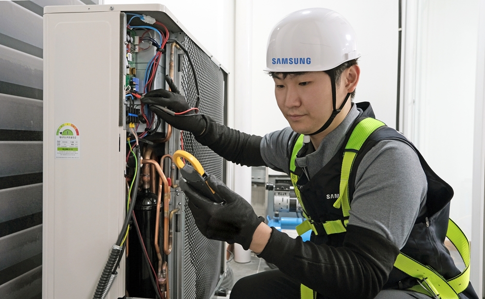 삼성전자서비스 엔지니어가 에어컨 실외기를 점검하는 모습.