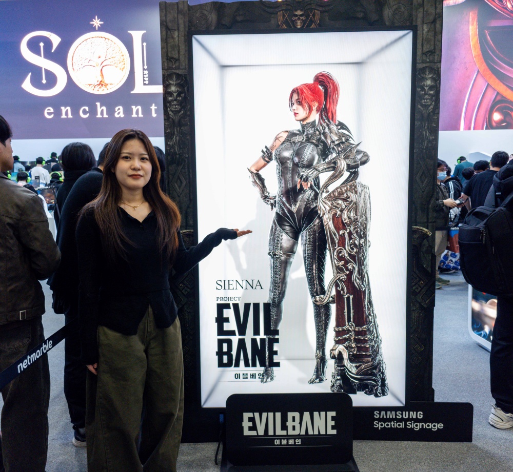 스페이셜 사이니지 개발에 참여한 삼성전자 남유진 프로가 지스타 2025 넷마블 부스에 설치된 제품 앞에서 포즈를 취하고 있다.
