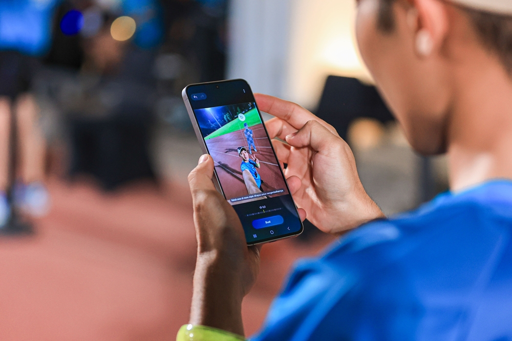 삼성전자 인도네시아 자카르타에서 열린 바통 대신 갤럭시 S25 FE 주고 받는 야간 이어달리기 NightstaFEt 행사에 참여한 러너가 달리면서 제품으로 콘텐츠를 편집하는 사진.