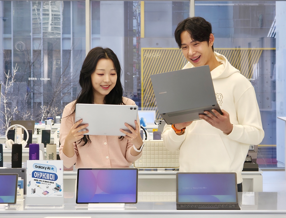 삼성전자 모델이 '갤럭시 북5 프로'와 '갤럭시 탭 S11 울트라'의 슬림한 디자인과 가벼운 무게를 체험하는 모습.