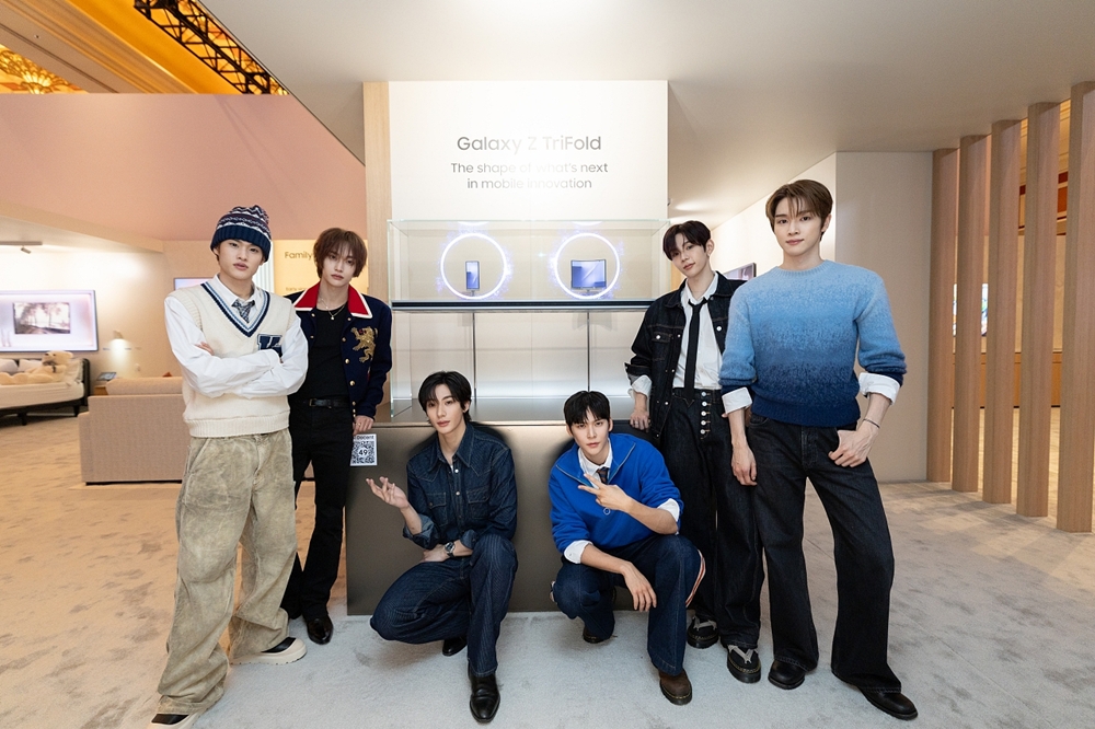 K팝 아티스트 라이즈(RIIZE)가 삼성전자 '더 퍼스트룩' 단독 전시관에서 두 번 접는 폴더블폰 '갤럭시 Z 트라이폴드'를 소개하고 있다.