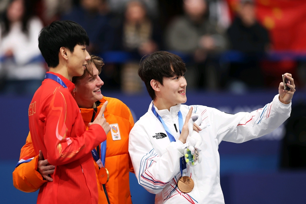 13일(한국시간) 이탈리아 밀라노 아이스스케이팅 아레나에서 열린 쇼트트랙 남자 1,000m 시상식에서 금메달 옌스 판트 바우트(네덜란드), 은메달 쑨룽(중국), 동메달 임종언(대한민국) 선수가 갤럭시 Z 플립7 올림픽 에디션으로 빅토리 셀피를 찍고 있다.