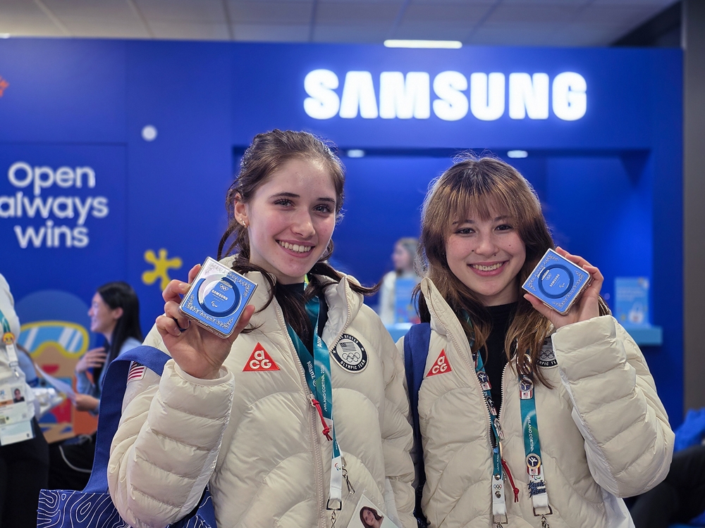 미국 피겨 스케이팅 선수들이 올림픽 선수촌 내 삼성 오픈 스테이션에서 ‘갤럭시 Z 플립7 올림픽 에디션’을 받고 즐거워하고 있다.