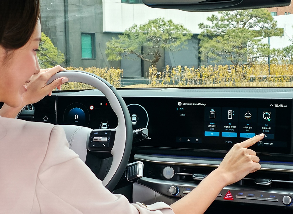 삼성전자 모델이 차량에서 집 안 가전기기를 제어하는 '카투홈(Car-to-Home)' 서비스를 체험하고 있다.