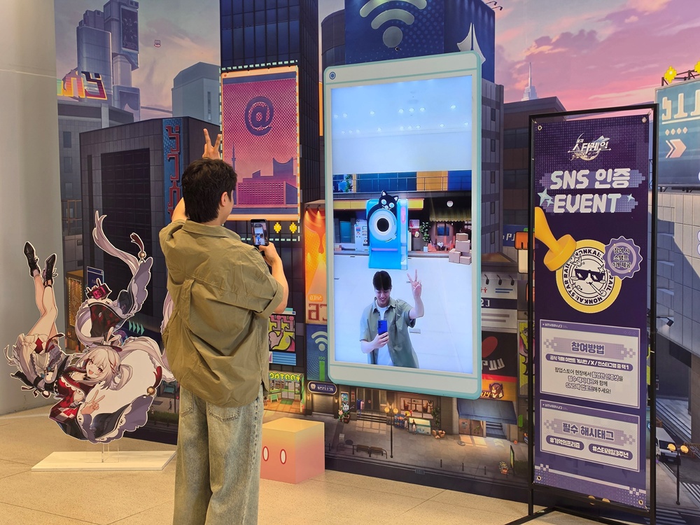 삼성스토어 홍대에 오픈한 '붕괴: 스타레일' 팝업스토어에 마련된 포토존에서 삼성전자 모델이 인증샷을 촬영하는 모습.
