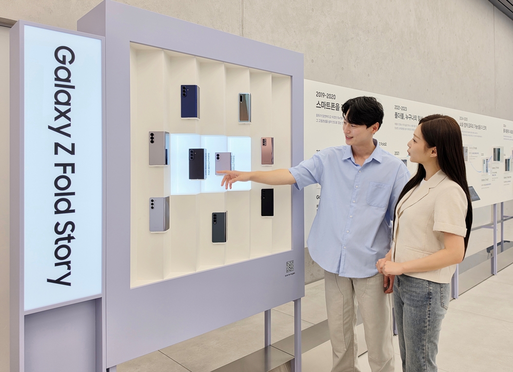 삼성전자 모델이 '폴더블 헤리티지'의 '갤럭시 폴드·플립 스토리' 섹션에서 역대 갤럭시 폴더블 라인업을 확인하는 모습.